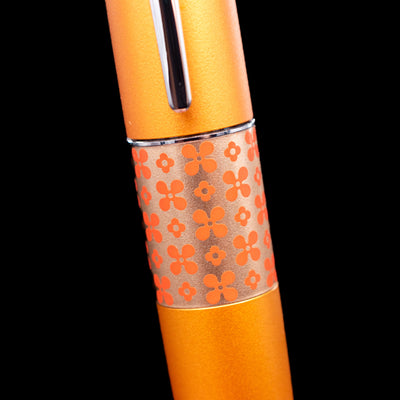 Close-up of the Pilot Metropolitan Pop Ballpoint Pen in Orange, highlighting the orange floral pattern on the center band.
