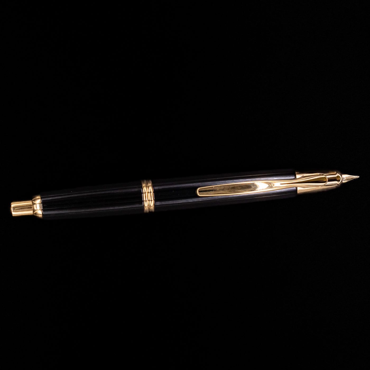 Full view of the Pilot Vanishing Point Fountain Pen in black with gold trim and clip on black background