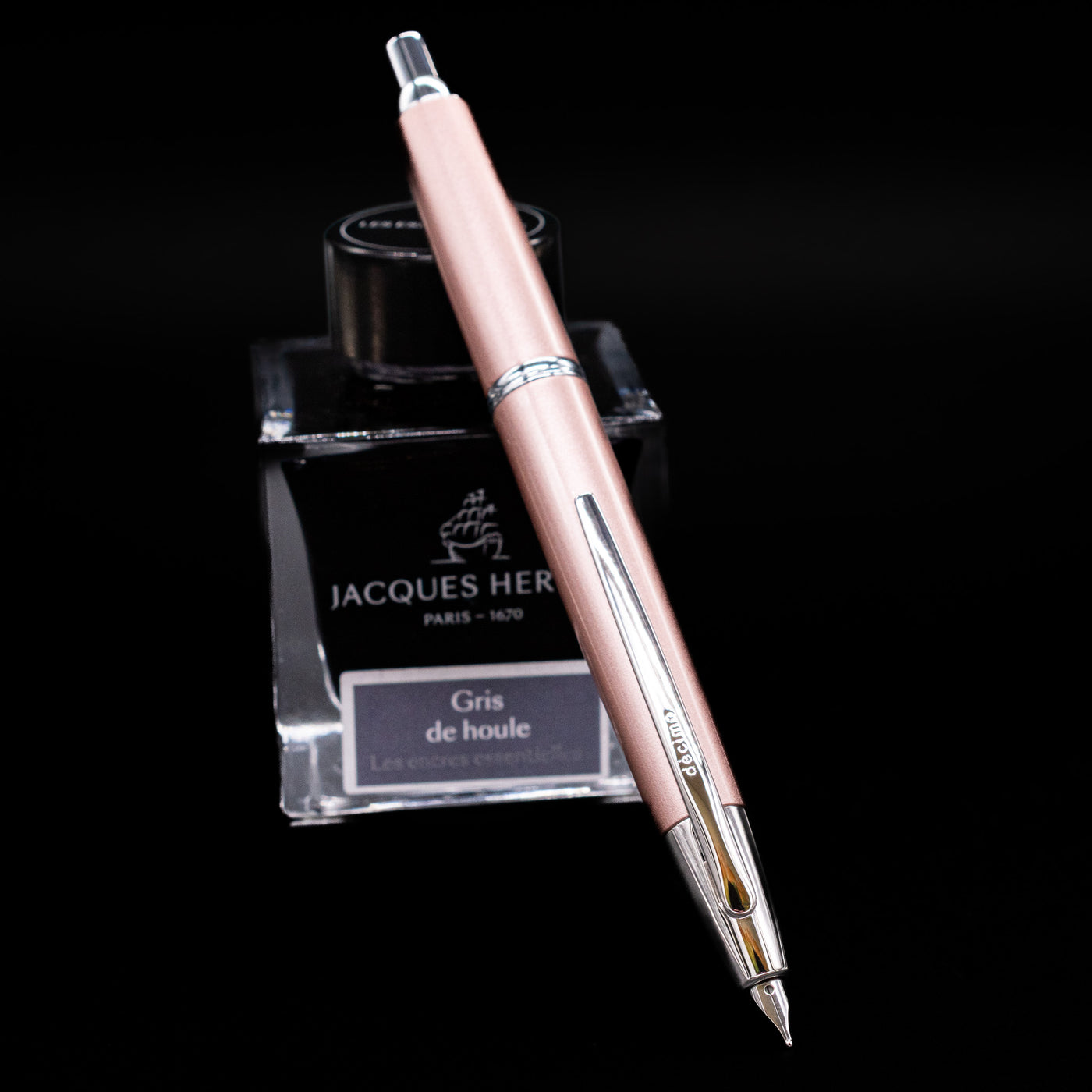 Pilot Vanishing Point Decimo Fountain Pen in Champagne resting on Jacques Herbin Gris de Houle ink bottle