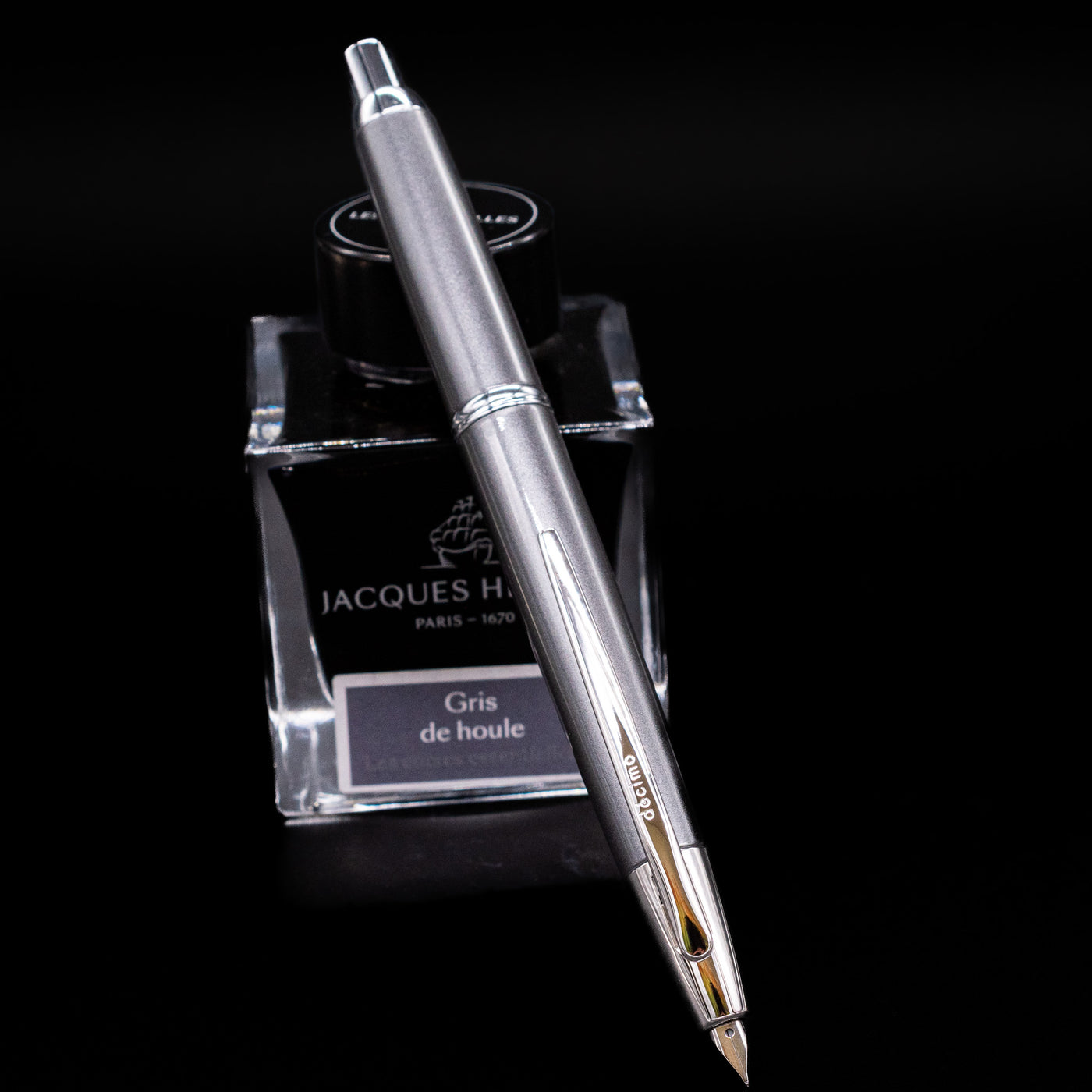 Pilot Vanishing Point Decimo Fountain Pen in Grey resting on Jacques Herbin Gris de Houle ink bottle