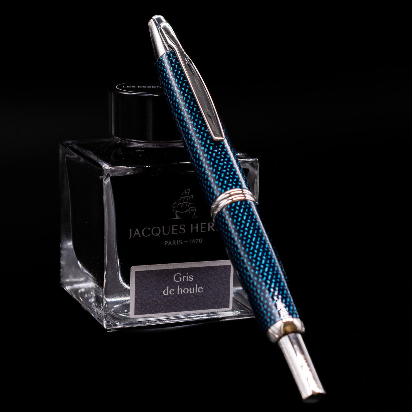 Pilot Vanishing Point Fountain Pen Blue Carbonesque resting on Jacques Herbin Gris de Houle ink bottle with nib extended