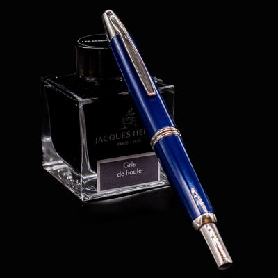 Pilot Vanishing Point Blue & Rhodium Fountain Pen displayed against a Jacques Herbin ink bottle for a stylish writing setup.