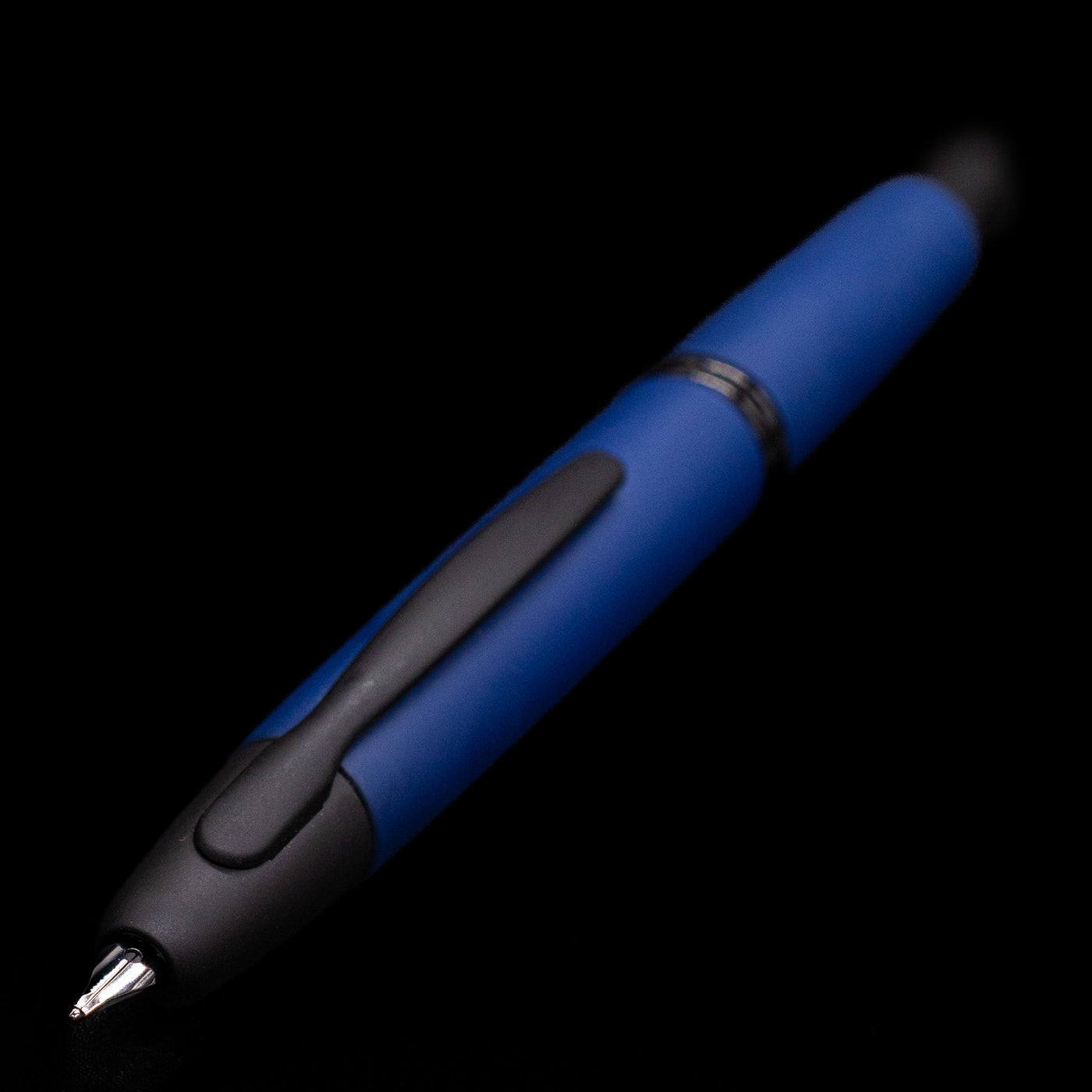 Close-up of the nib and clip of the Pilot Vanishing Point Fountain Pen Matte Blue against a dark background.