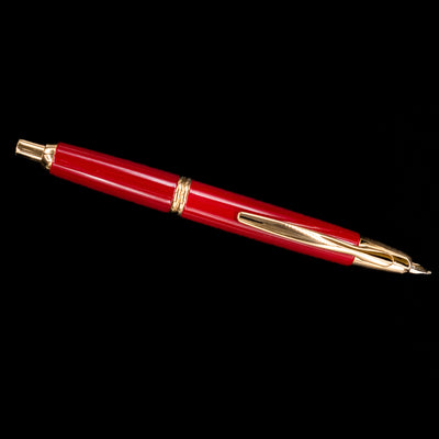Full-length image of Pilot Vanishing Point Fountain Pen in Red and Gold against black background