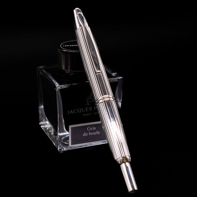 Pilot Vanishing Point Stripes Fountain Pen angled over Jacques Herbin Gris de Houle ink bottle