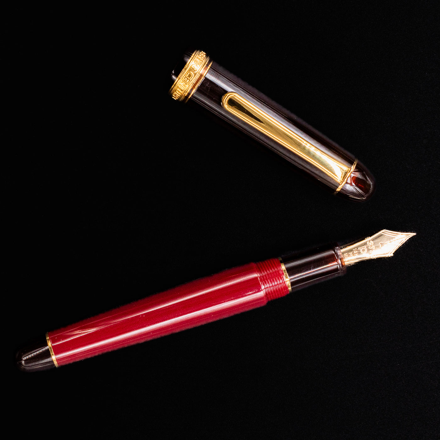 Flat lay of Platinum 3776 Century Fountain Pen in Coffee Jelly with cap off showing gold nib and translucent brown accents
