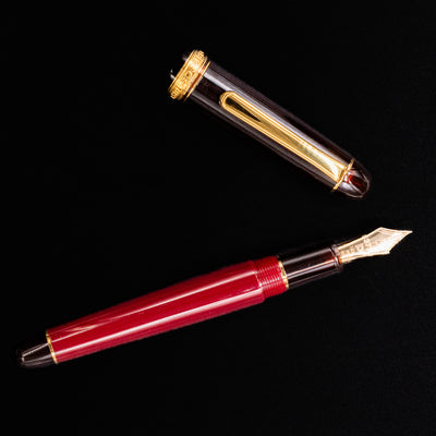 Flat lay of Platinum 3776 Century Fountain Pen in Coffee Jelly with cap off showing gold nib and translucent brown accents