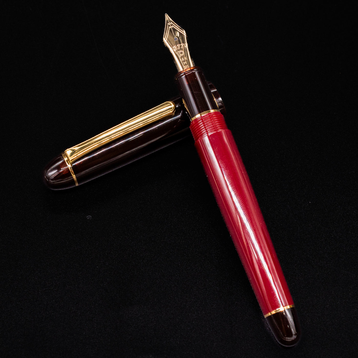 Platinum 3776 Century Fountain Pen open on black background with gold nib and Coffee Jelly cap beside it