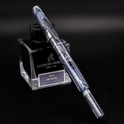 Platinum Curidas Fountain Pen - Graphite Smoke fully capped and displayed with a Jacques Herbin Gris de Houle ink bottle
