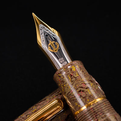Close-up of the Sailor King of Pens Naginata Togi Syokei Fountain Pen nib, showing the 21k gold and rhodium-plated nib with anchor emblem and marbled ebonite grip.