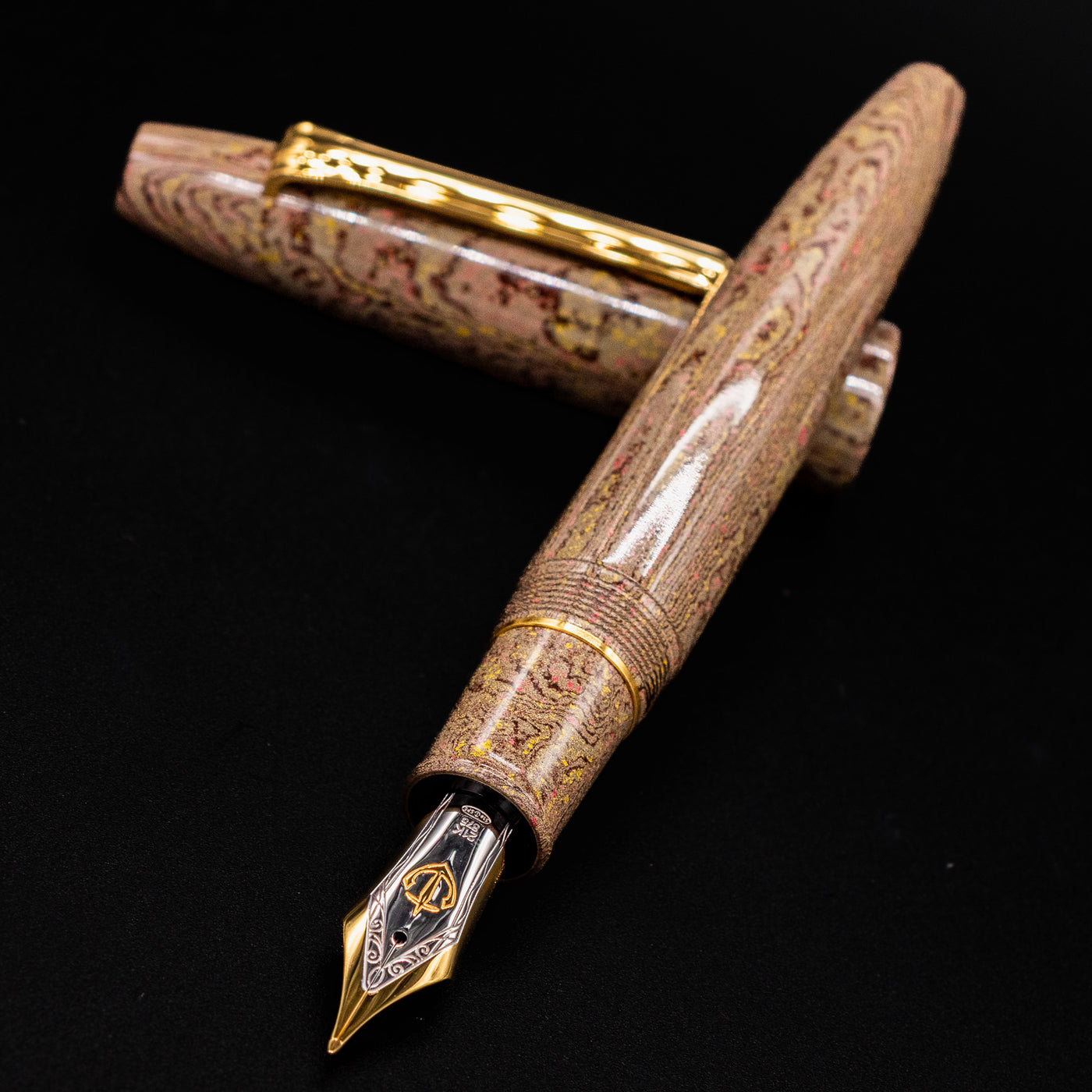 Close-up of the Sailor King of Pens Naginata Togi Syokei Fountain Pen, showcasing the detailed two-tone nib and marbled ebonite body against a black background.