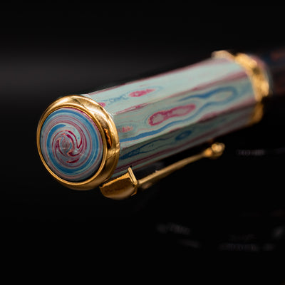 Close-up of the cap finial on the Santini Giant 8 Faceted Burano Fountain Pen, highlighting the swirling pastel design and gold trim detail.