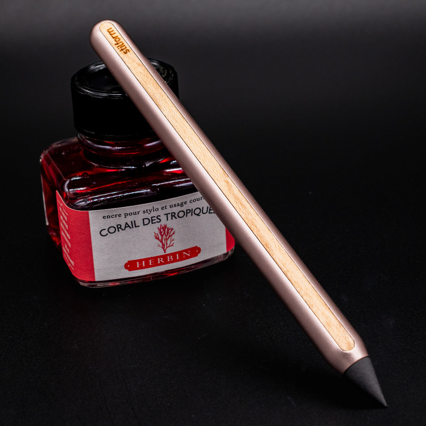 Stilform AEON Pencil Rose Moon Aluminum - leaning on ink bottle