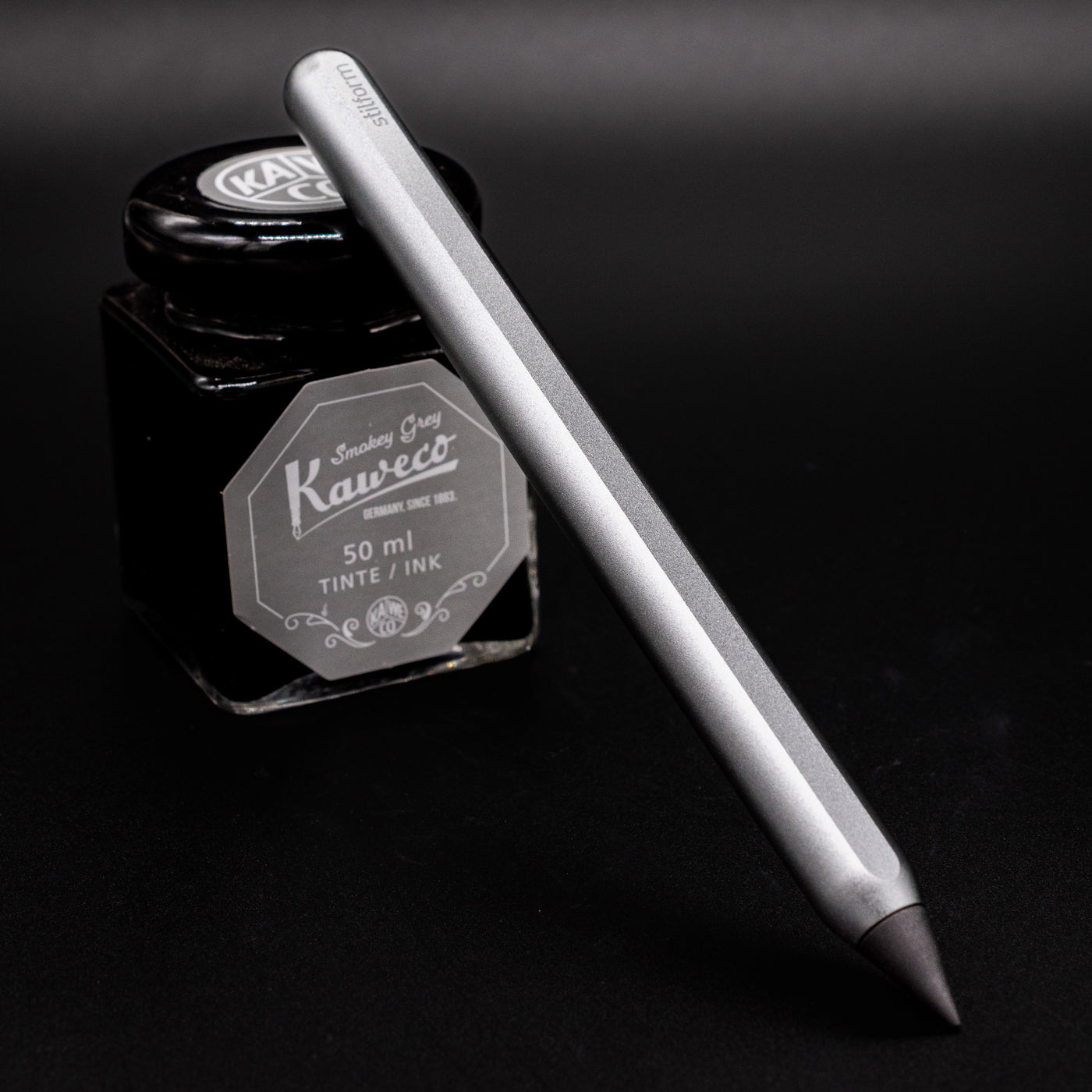 Stilform AEON Pencil Comet Grey - leaning on ink bottle