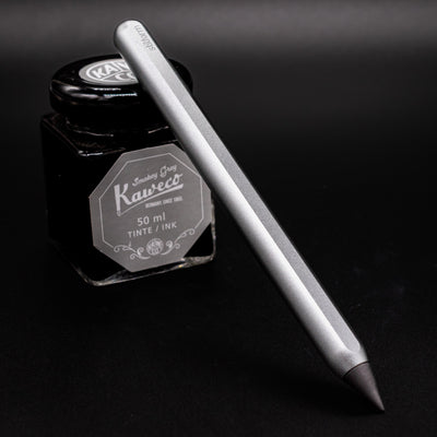 Stilform AEON Pencil Comet Grey - leaning on ink bottle