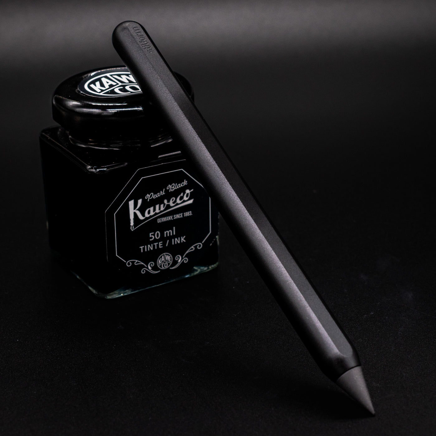 Stilform AEON Pencil Warp Black - leaning on ink bottle
