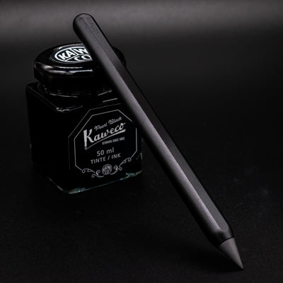 Stilform AEON Pencil Warp Black - leaning on ink bottle