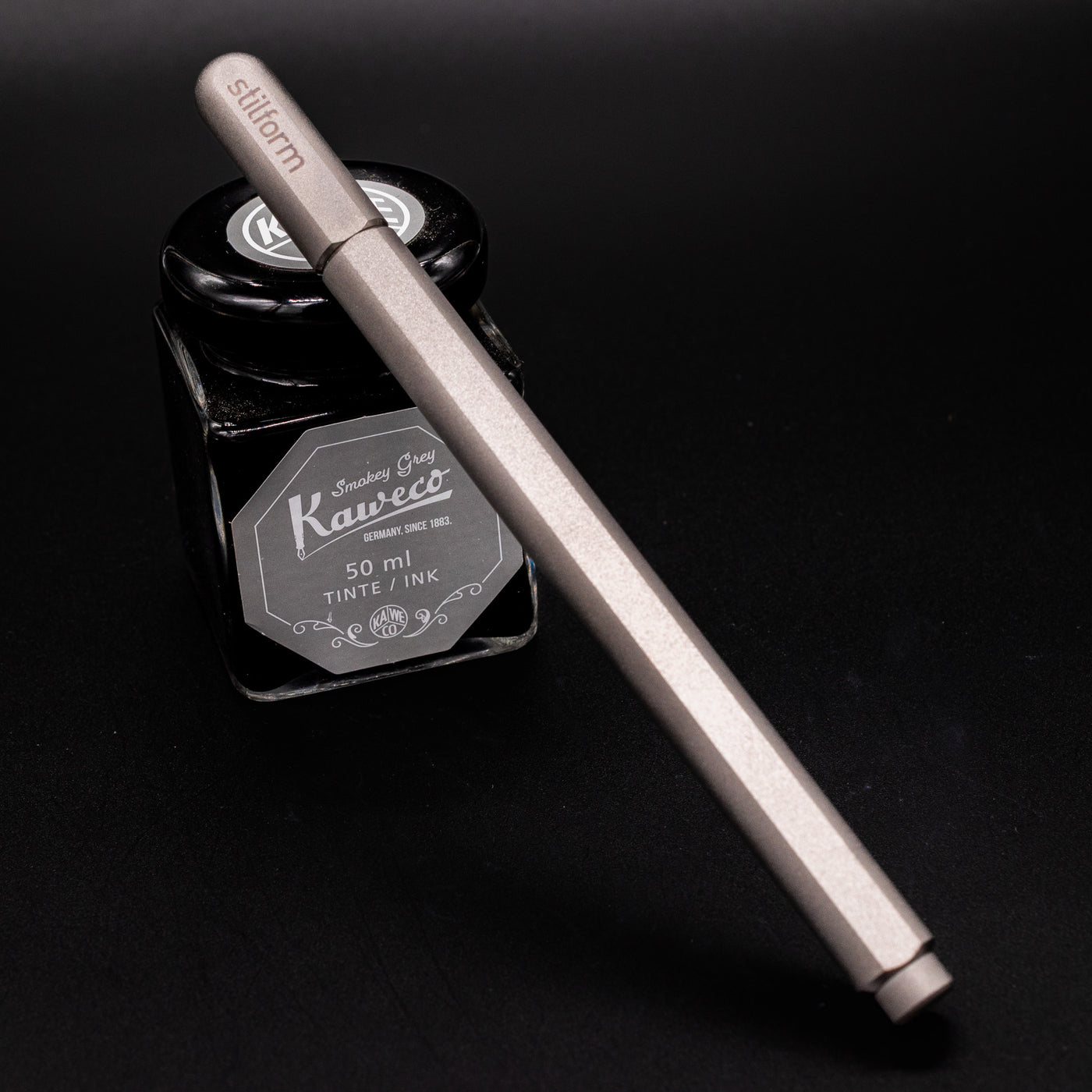 Stilform ARC Gel Pen Comet Grey - capped and leaning on ink bottle