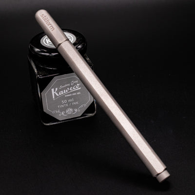Stilform ARC Gel Pen Comet Grey - capped and leaning on ink bottle