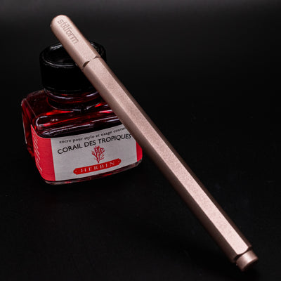Stilform ARC Gel Pen Rose Moon Aluminum - capped and leaning on ink bottle