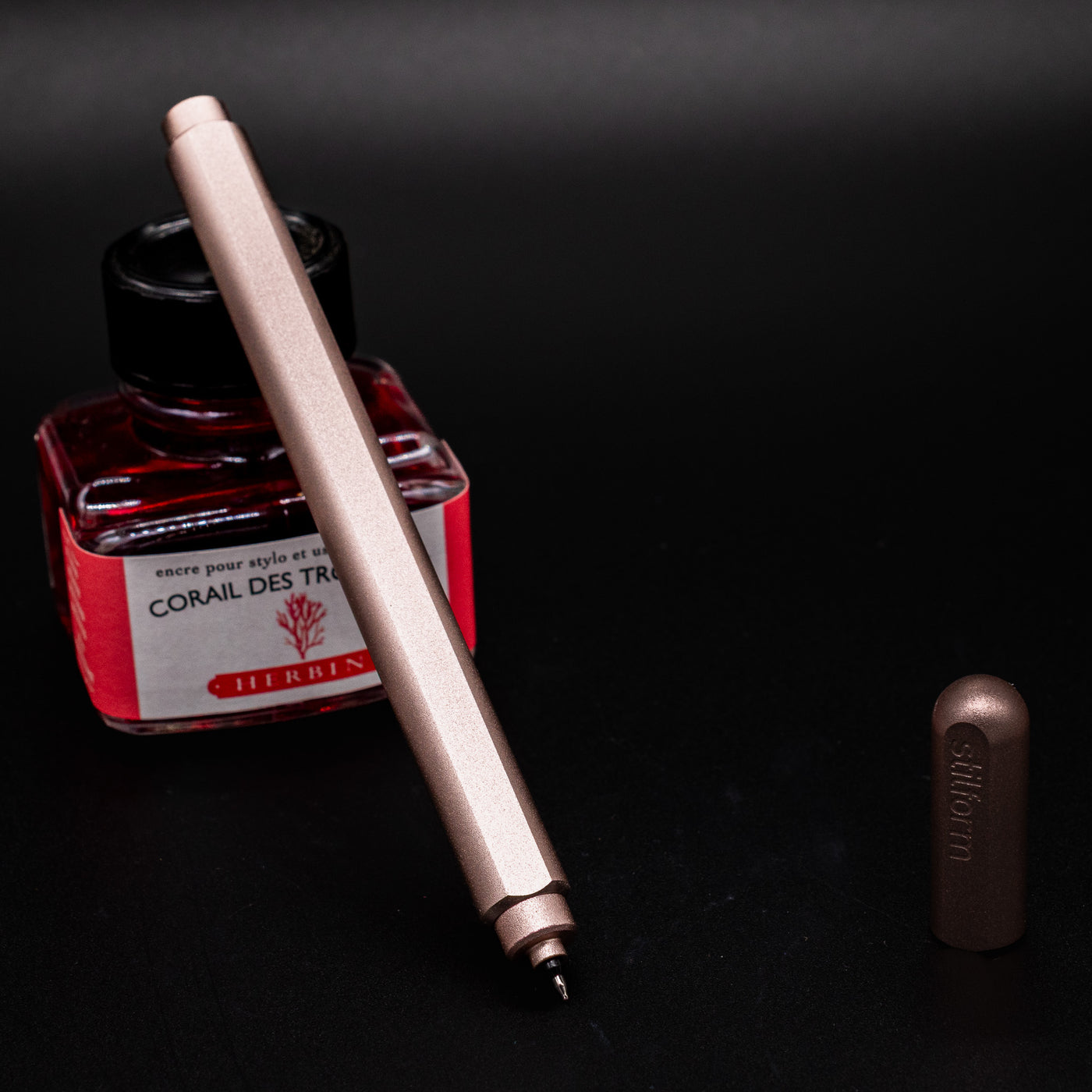 Stilform ARC Gel Pen Rose Moon Aluminum - uncapped and leaning on ink bottle