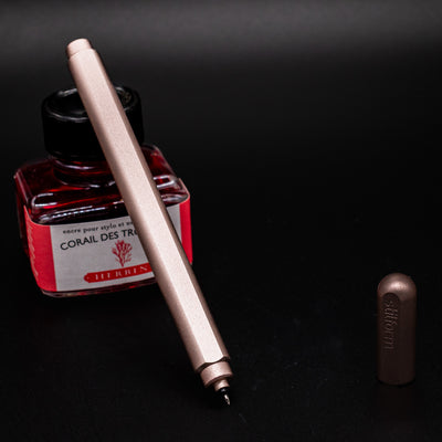 Stilform ARC Gel Pen Rose Moon Aluminum - uncapped and leaning on ink bottle