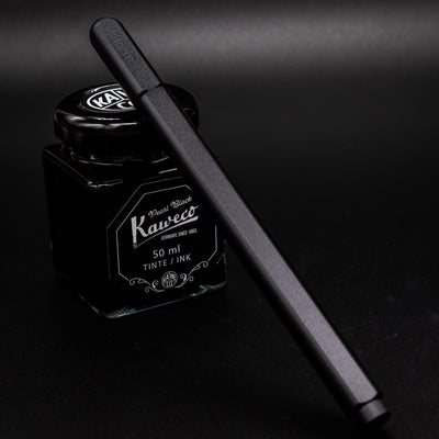 Stilform ARC Gel Pen Titanium DLC - capped and leaning on ink bottle