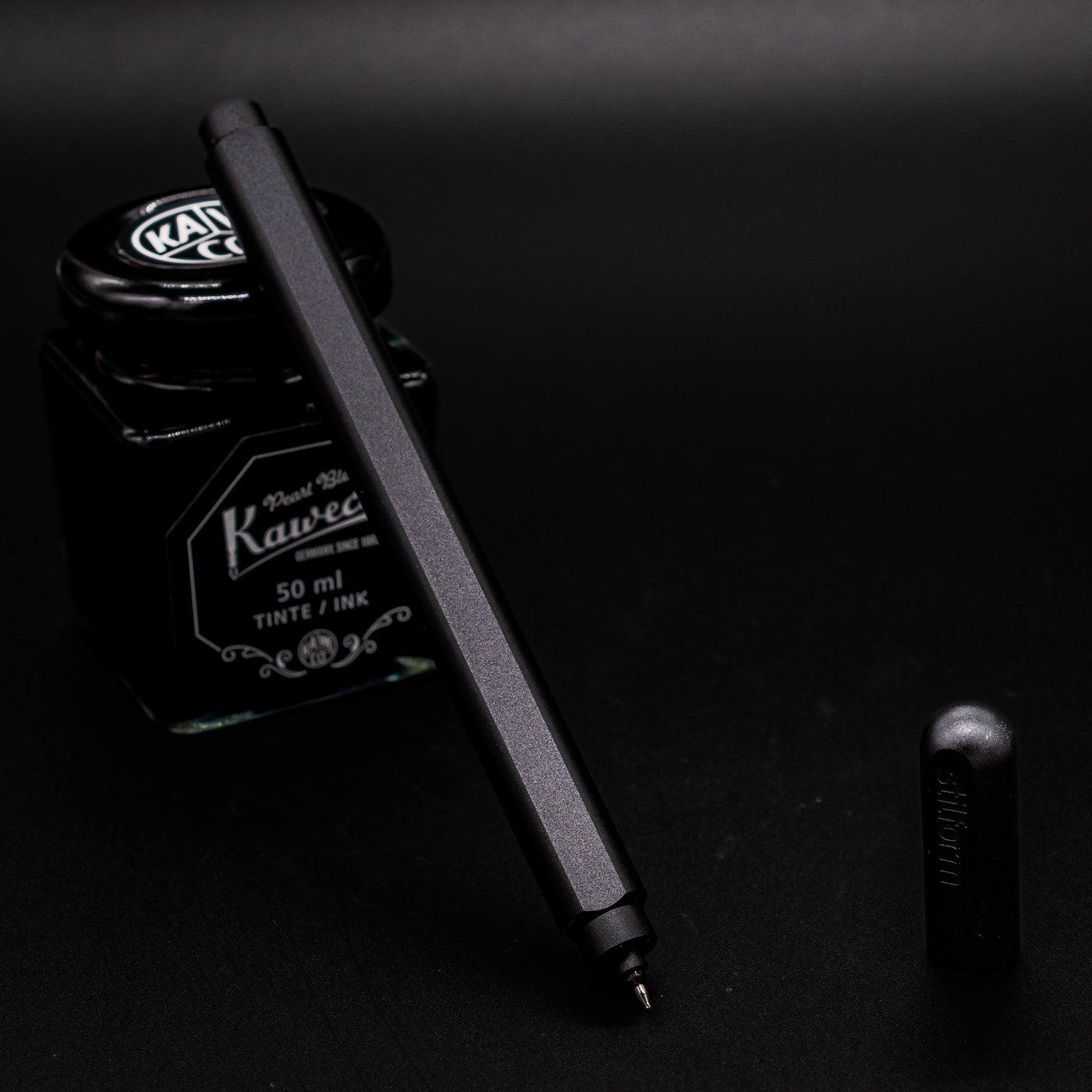 Stilform ARC Gel Pen Titanium DLC - uncapped and leaning on ink bottle
