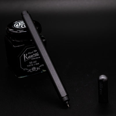 Stilform ARC Gel Pen Titanium DLC - uncapped and leaning on ink bottle