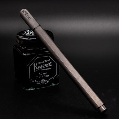 Stilform ARC Gel Pen Titanium Matte - capped and leaning on ink bottle