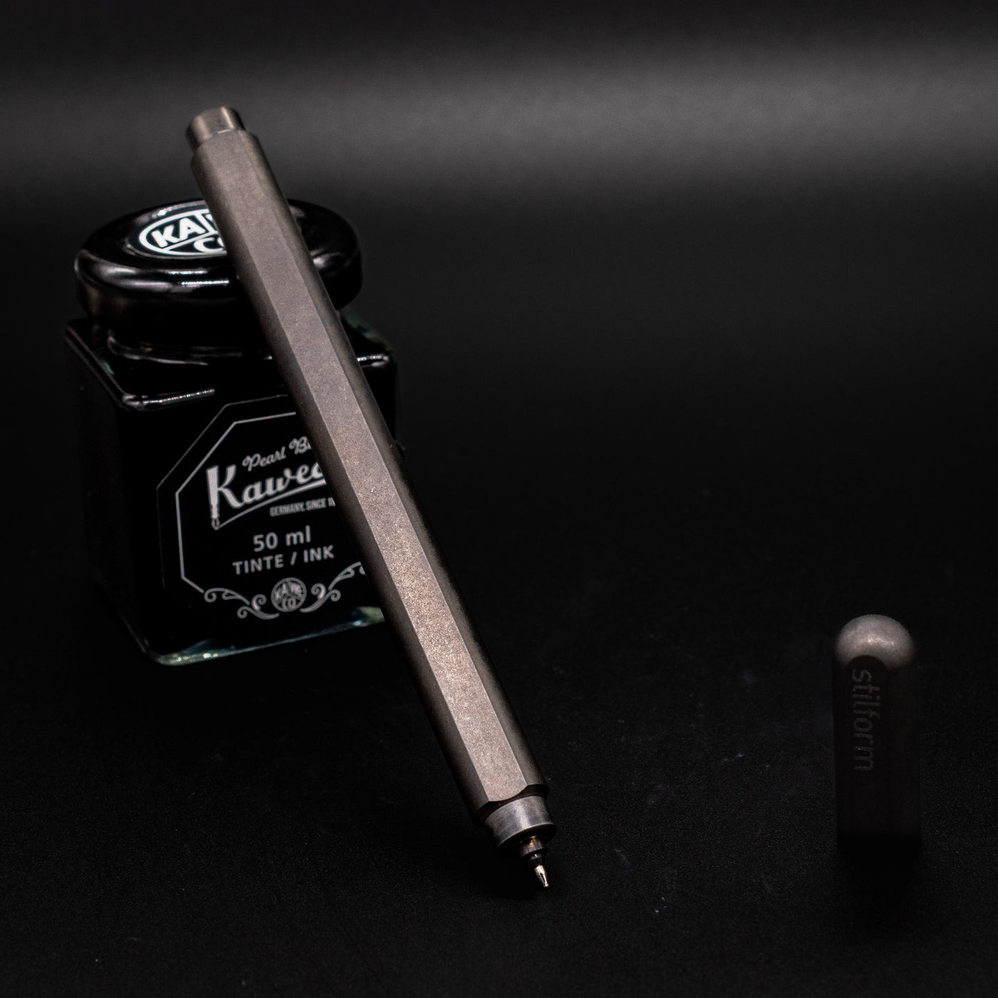 Stilform ARC Gel Pen Titanium Matte - uncapped and leaning on ink bottle