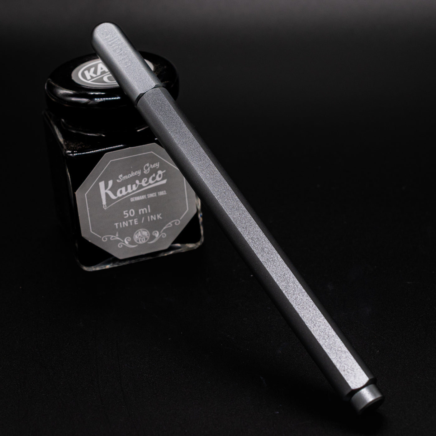 Stilform ARC Gel Pen Warp Black - capped and leaning on ink bottle