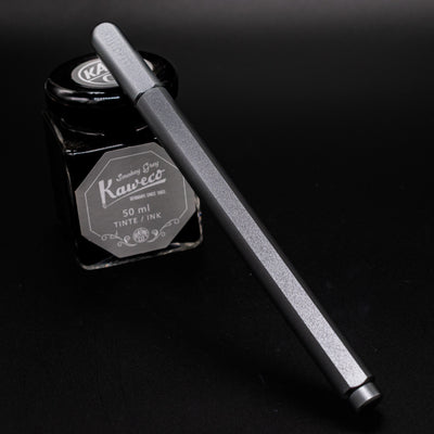Stilform ARC Gel Pen Warp Black - capped and leaning on ink bottle