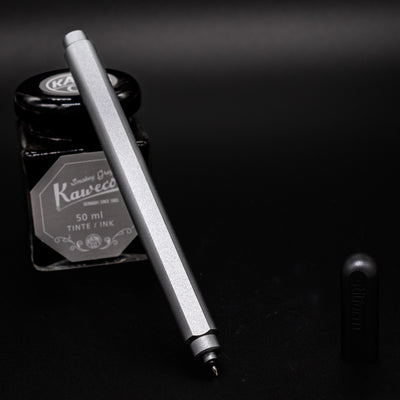 Stilform ARC Gel Pen Warp Black - uncapped and leaning on ink bottle