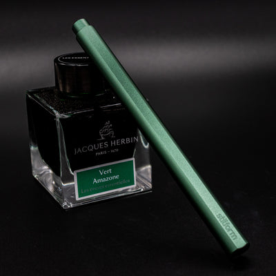 Stilform FLOW Rollerball Pen Aurora Green - capped and leaning on ink bottle