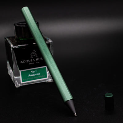 Stilform FLOW Rollerball Pen Aurora Green - uncapped and leaning on ink bottle