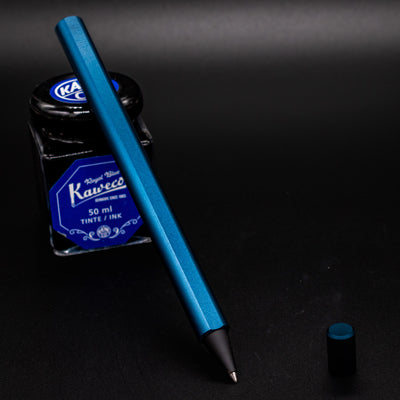 Stilform FLOW Rollerball Pen Night Sky Aluminum - uncapped and leaning on ink bottle