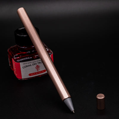 Stilform FLOW Rollerball Pen Rose Moon Aluminum - uncapped and leaning on ink bottle