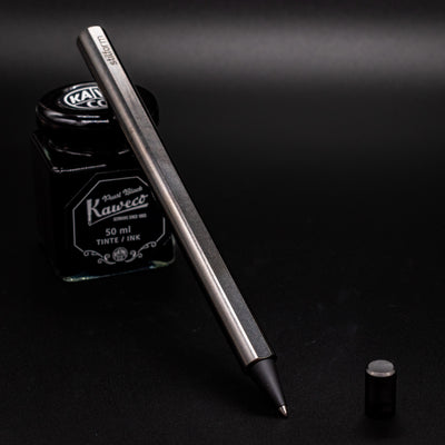 Stilform FLOW Rollerball Pen Titanium DLC - Uncapped and leaning on ink bottle