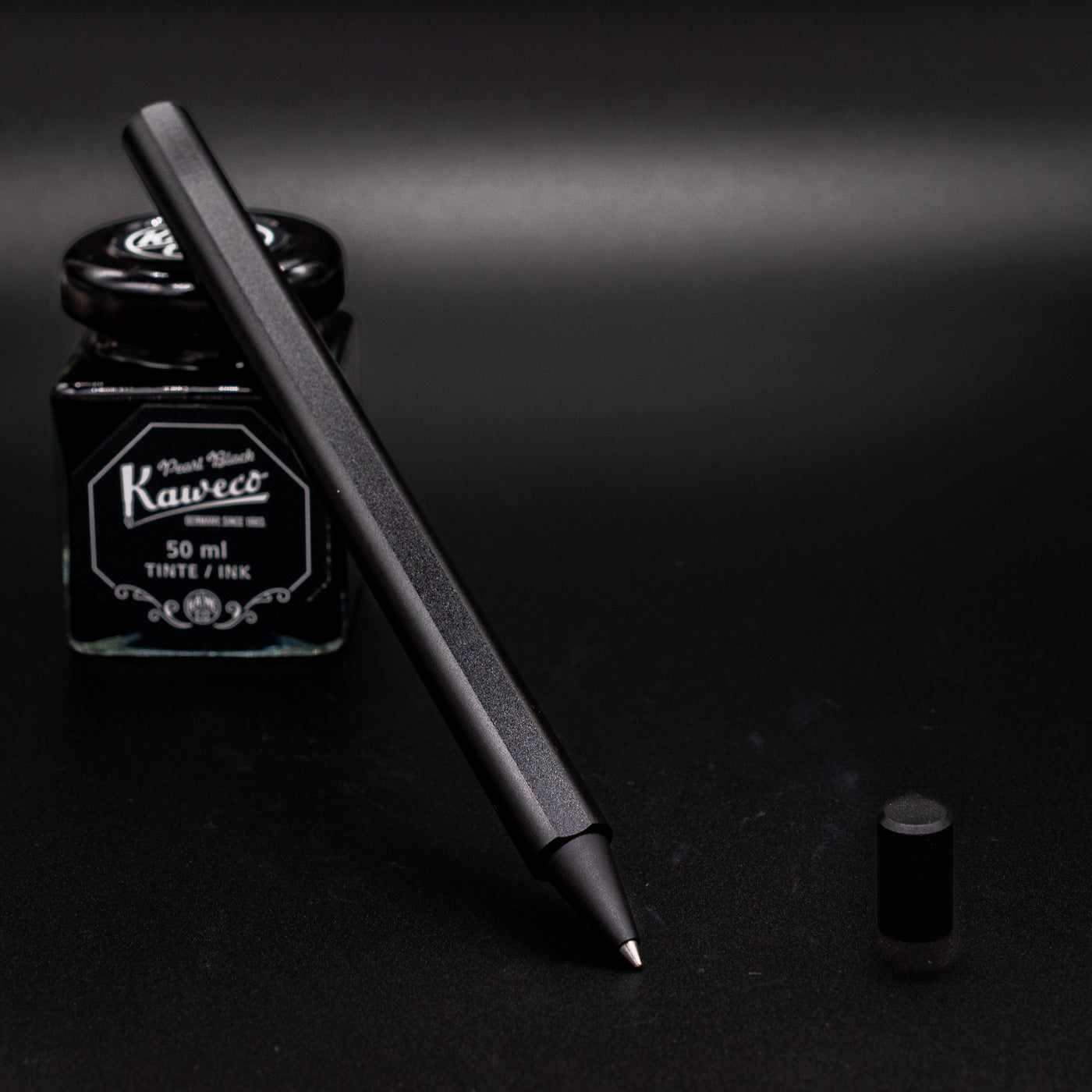 Stilform FLOW Rollerball Pen Warp Black - uncapped and leaning on ink bottle