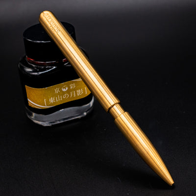 Stilform PEN Ballpoint Pen Brass Radial Brushed - pen leaning on ink bottle