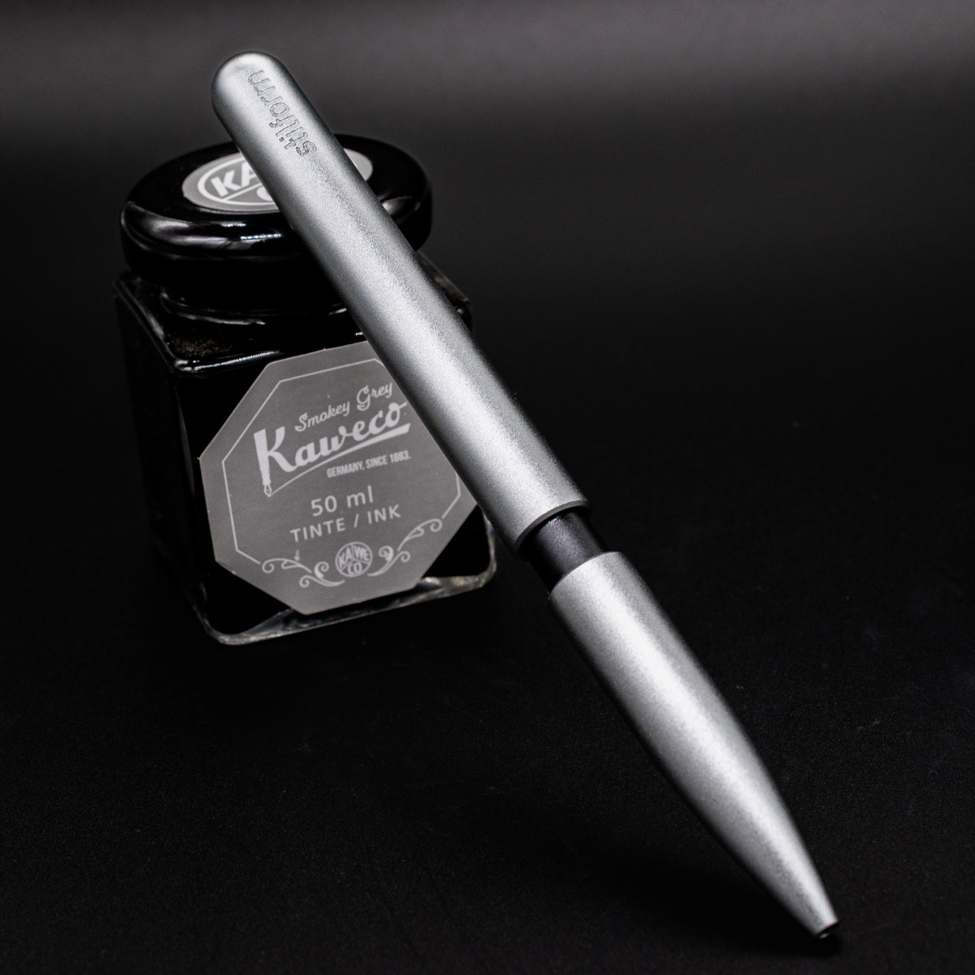 Stilform PEN Ballpoint Pen Comet Grey - pen leaning on ink bottle