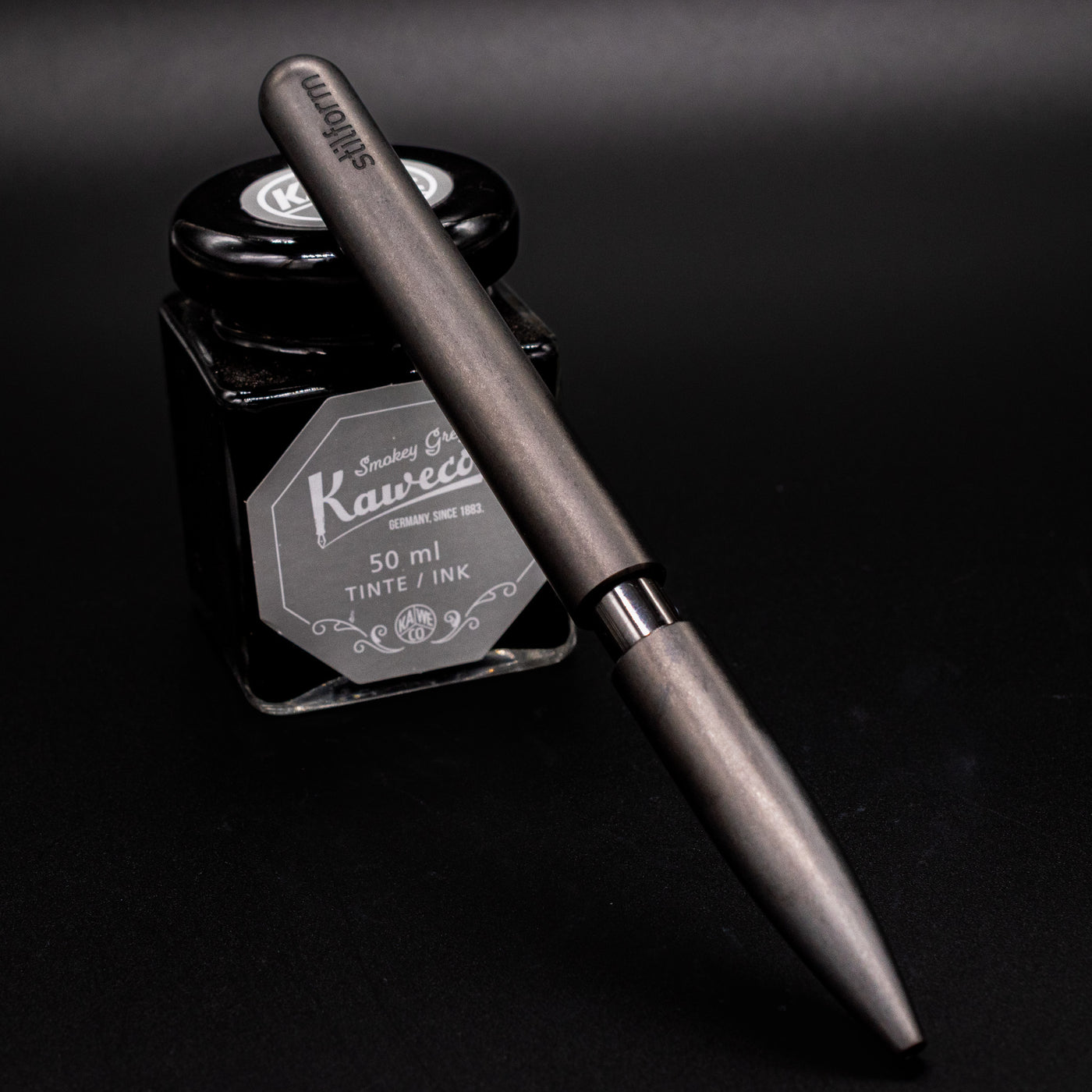 Stilform PEN Ballpoint Pen Titanium DLC - pen leaning on ink bottle