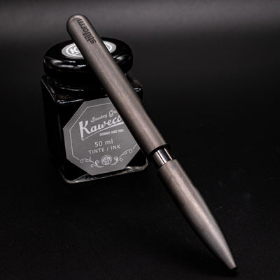 Stilform PEN Ballpoint Pen Titanium DLC - pen leaning on ink bottle
