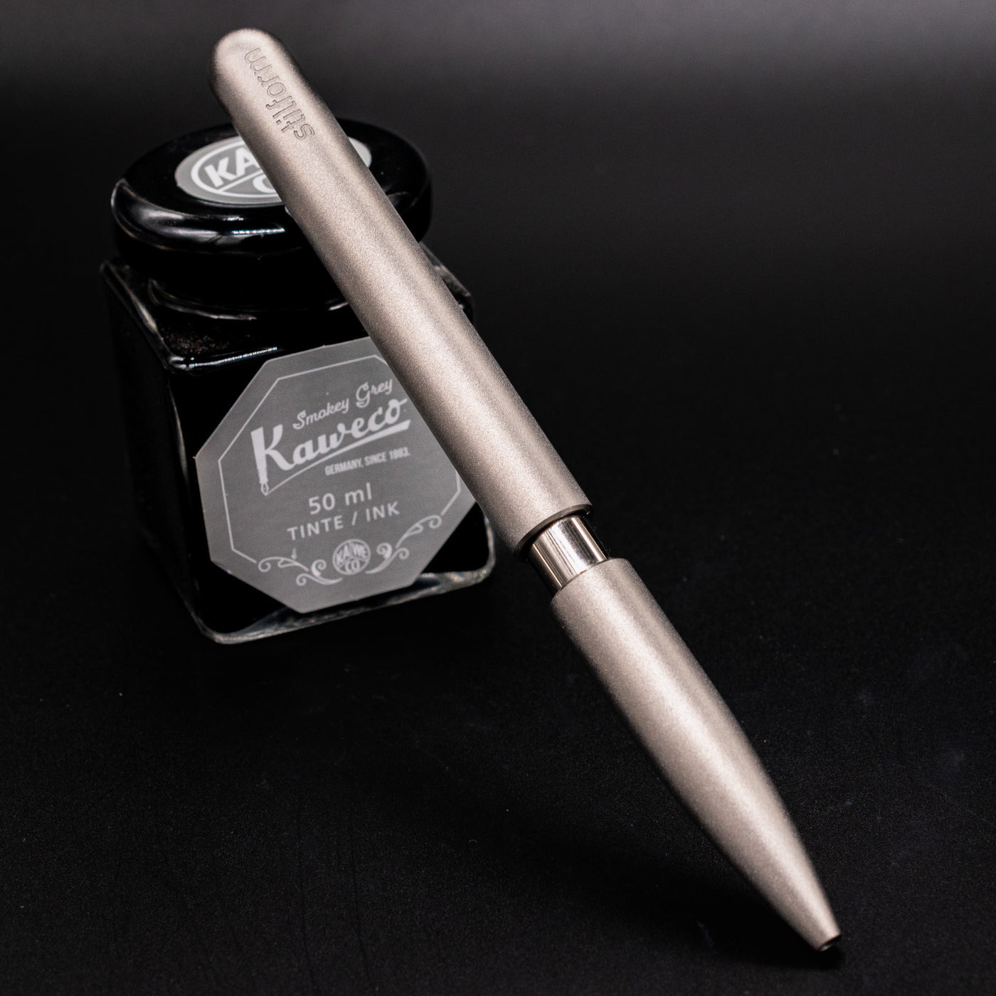 Stilform PEN Ballpoint Pen Titanium Matte - pen leaning on ink bottle