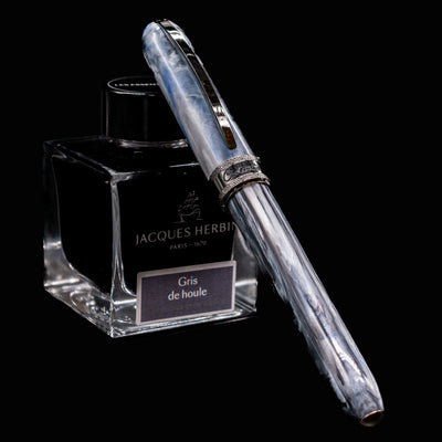 Visconti Comedia Caronte Fountain Pen capped and resting on Jacques Herbin Gris de Houle ink bottle.