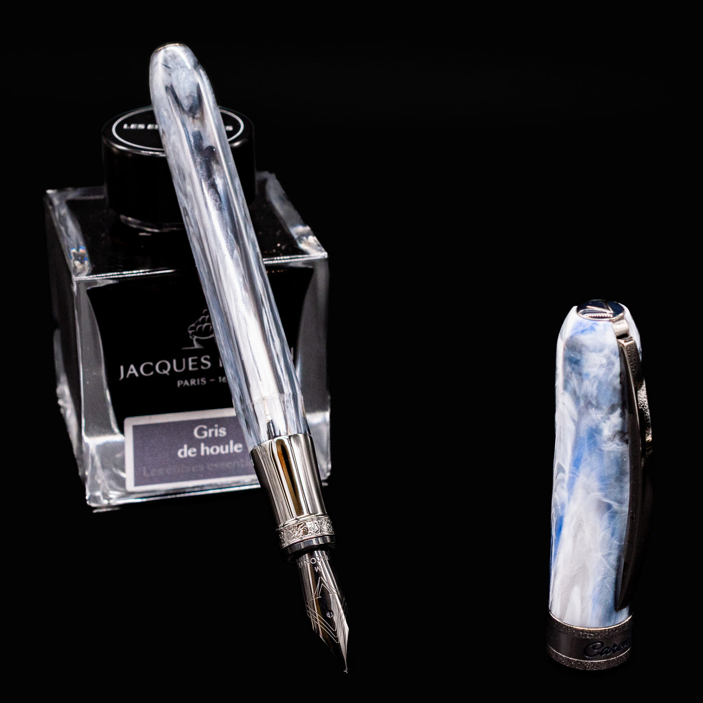 Visconti Comedia Limited Edition Caronte Fountain Pen with nib exposed, resting on Jacques Herbin Gris de Houle ink bottle.