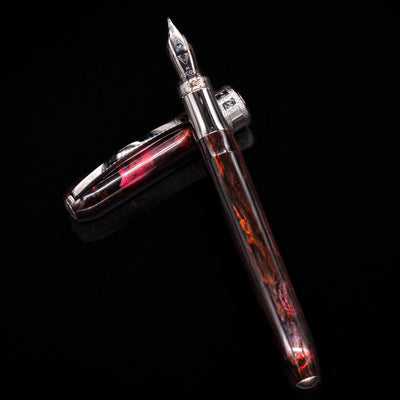 Visconti Comedia Inferno Fountain Pen shown open with cap laying beside it on black background