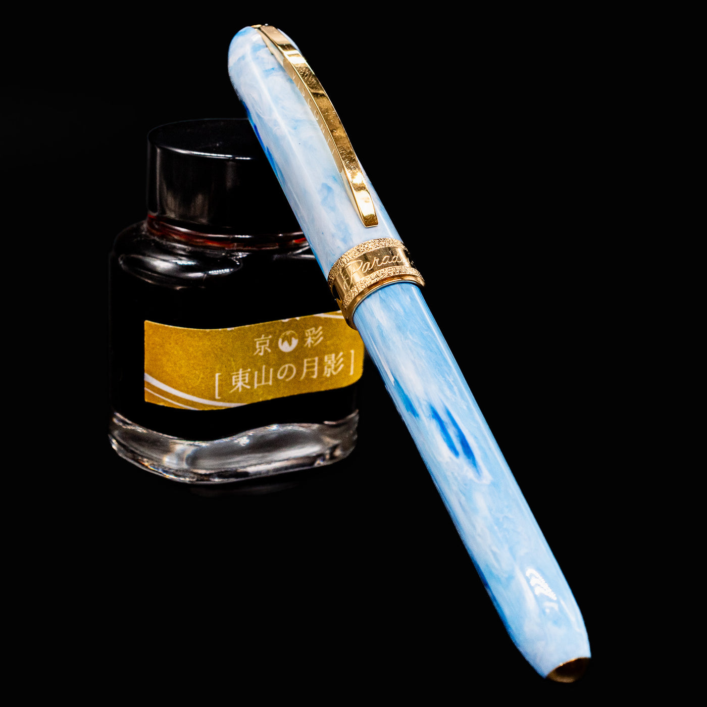 Visconti Comedia Paradiso fountain pen capped and resting on yellow-labeled ink bottle.