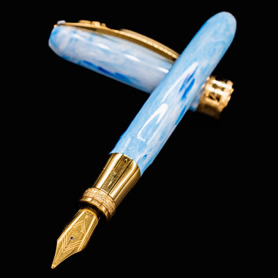 Close-up of Visconti Comedia Paradiso fountain pen nib with gold trim and blue resin body.